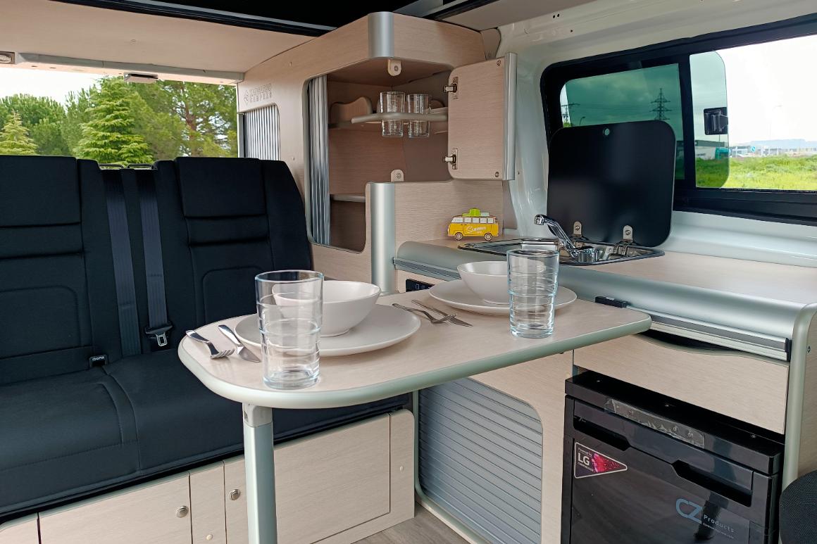 Camper Ford Melbourne en alquiler con la mesa puesta lista para comer
